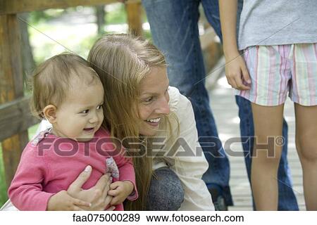 Mother hugging infant in woods View Large Photo Image Stock Photo - Mother hugging infant in woods. Fotosearch