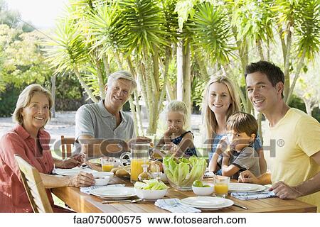 Multi-generation family at breakfast table outdoors, portrait View Large Photo Image Stock Photography - Multi-generation family at breakfast table outdoors, portrait. Fotosearch