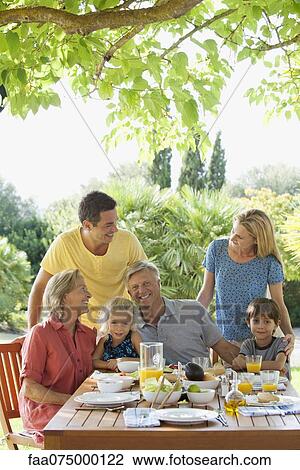 Multi-generation family having breakfast outdoors View Large Photo Image Stock Image - Multi-generation family having breakfast outdoors. Fotosearch