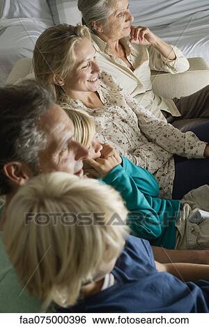 Multi-generation family sitting side by side on sofa, high angle view View Large Photo Image Stock Photograph - Multi-generation family sitting side by side on sofa, high angle view. Fotosearch