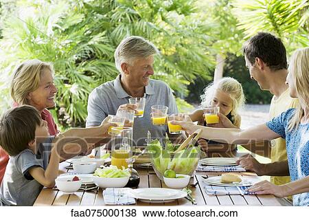 Multi-generation family toasting with orange juice outdoors, portrait View Large Photo Image Stock Photo - Multi-generation family toasting with orange juice outdoors, portrait. Fotosearch
