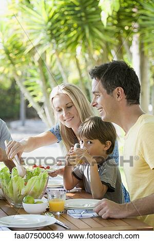 Parents and young son having breakfast outdoors View Large Photo Image Stock Photo - Parents and young son having breakfast outdoors. Fotosearch