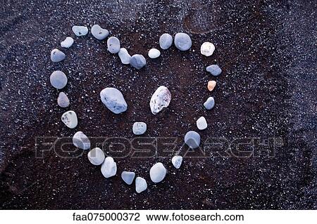 Pebbles arranged in heart shape on black sand View Large Photo Image Stock Image - Pebbles arranged in heart shape on black sand. Fotosearch