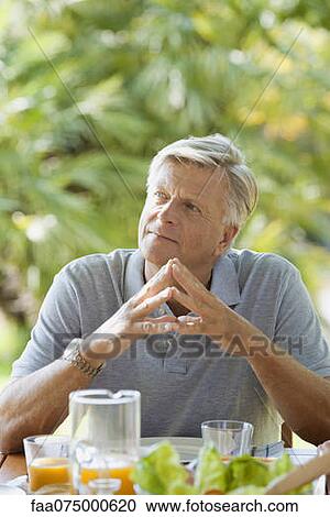 Senior man having breakfast outdoors, portrait View Large Photo Image Stock Image - Senior man having breakfast outdoors, portrait. Fotosearch
