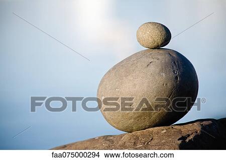 Small stone stacked on top of larger stone View Large Photo Image Picture - Small stone stacked on top of larger stone. Fotosearch