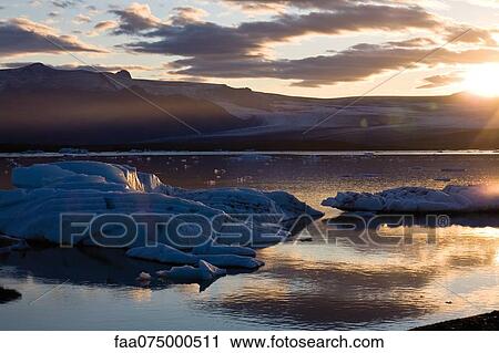 Stock Image - Sun setting over Jokulsarlon glacial lagoon, Iceland. Fotosearch