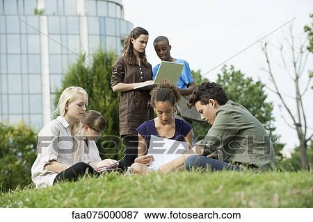 Stock Photo - University students studying together outdoors. Fotosearch