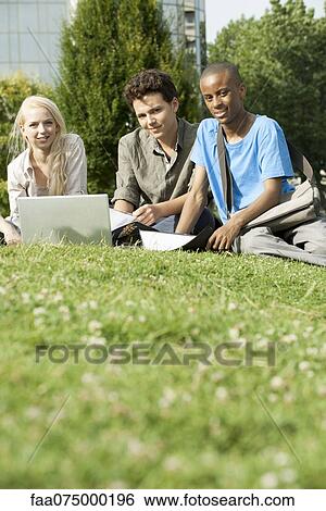 University students studying together on grass, low angle view View Large Photo Image Stock Photograph - University students studying together on grass, low angle view. Fotosearch