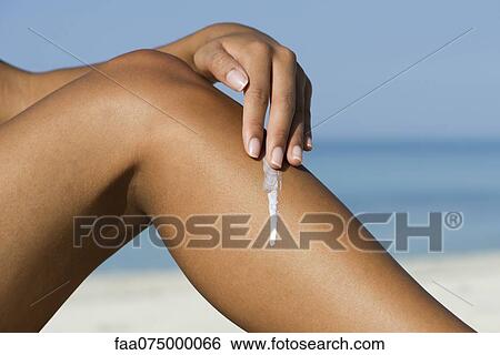 Woman applying sunscreen to leg at the beach, cropped View Large Photo Image Stock Photograph - Woman applying sunscreen to leg at the beach, cropped. Fotosearch