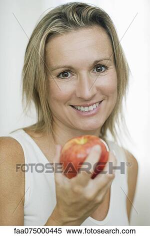 Woman holding apple, portrait View Large Photo Image Stock Photography - Woman holding apple, portrait. Fotosearch