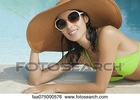 Woman in sun hat relaxing by pool, portrait View Large Photo Image Stock Photograph - Woman in sun hat relaxing by pool, portrait. Fotosearch