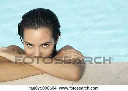 Picture - Woman in swimming pool, resting head on arms, portrait. Fotosearch