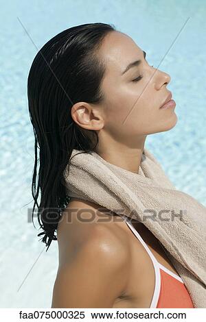 Stock Photography - Woman relaxing by pool, profile. Fotosearch