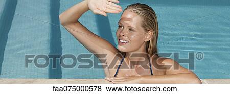 Woman relaxing in pool, looking away and shading eyes View Large Photo Image Stock Photo - Woman relaxing in pool, looking away and shading eyes. Fotosearch