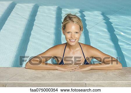 Woman relaxing in pool, portrait View Large Photo Image Picture - Woman relaxing in pool, portrait. Fotosearch