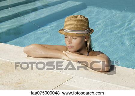 Stock Photo - Woman relaxing in pool with chin resting on hands. Fotosearch