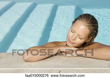Stock Photograph - Woman relaxing in pool with eyes closed. Fotosearch