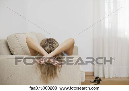 Woman resting on sofa, rear view View Large Photo Image Stock Photo - Woman resting on sofa, rear view. Fotosearch