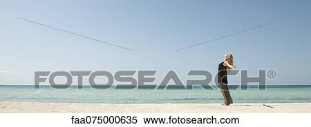 Woman standing on beach with head back and arms outstretched View Large Photo Image Stock Photography - Woman standing on beach with head back and arms outstretched. Fotosearch