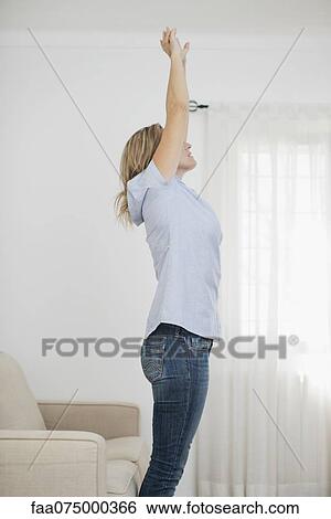 Woman stretching in living room View Large Photo Image Stock Photograph - Woman stretching in living room. Fotosearch