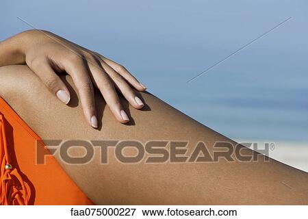Woman sunbathing at the beach, close-up of hand on hip View Large Photo Image Stock Photo - Woman sunbathing at the beach, close-up of hand on hip. Fotosearch