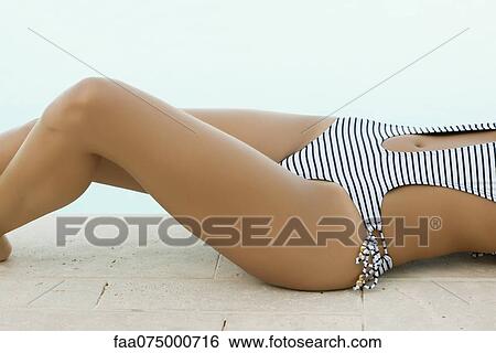 Woman sunbathing beside pool, cropped View Large Photo Image Stock Photograph - Woman sunbathing beside pool, cropped. Fotosearch