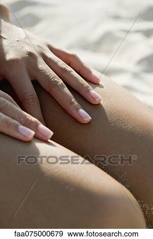 Woman touching bare legs at the beach, cropped View Large Photo Image Stock Photo - Woman touching bare legs at the beach, cropped. Fotosearch
