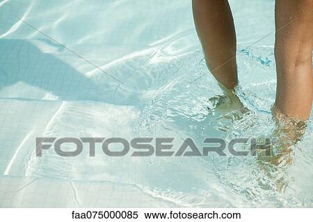 Stock Photography - Woman wading in pool, cropped. Fotosearch