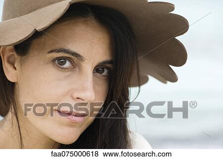 Stock Photo - Woman wearing sun hat, portrait. Fotosearch