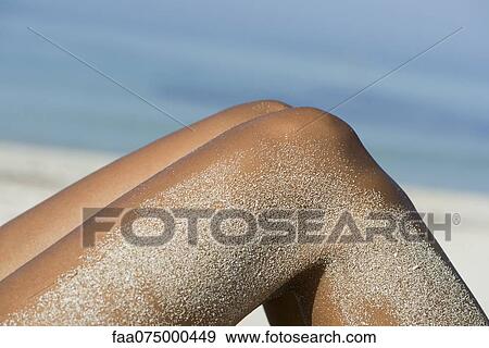 Woman's legs coated in sand at the beach View Large Photo Image Stock Photo - Woman's legs coated in sand at the beach. Fotosearch