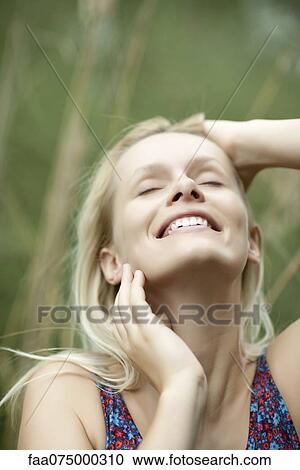 Yong woman smiling with face turning upwards View Large Photo Image Stock Image - Yong woman smiling with face turning upwards. Fotosearch