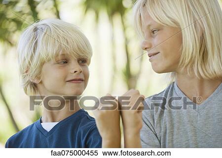 Young brothers bumping fists and smiling at each other View Large Photo Image Stock Photography - Young brothers bumping fists and smiling at each other. Fotosearch
