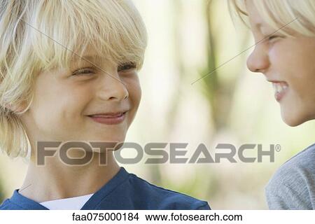 Young brothers smiling at each other View Large Photo Image Picture - Young brothers smiling at each other. Fotosearch