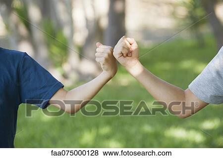 Young friends doing fist bump, cropped View Large Photo Image Stock Photo - Young friends doing fist bump, cropped. Fotosearch
