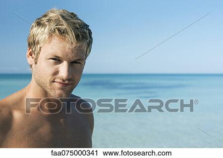 Young man on beach, portrait View Large Photo Image Stock Image - Young man on beach, portrait. Fotosearch