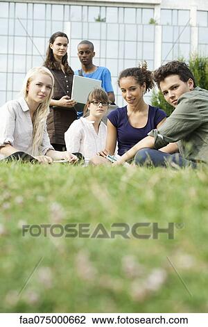 Young people hanging out on grass View Large Photo Image Stock Image - Young people hanging out on grass. Fotosearch