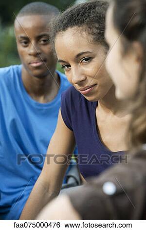 Young people outdoors, focus on one young woman View Large Photo Image Stock Photograph - Young people outdoors, focus on one young woman. Fotosearch