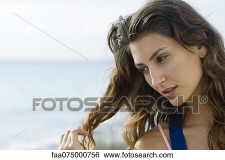 Stock Photograph - Young woman daydreaming outdoors, portrait. Fotosearch