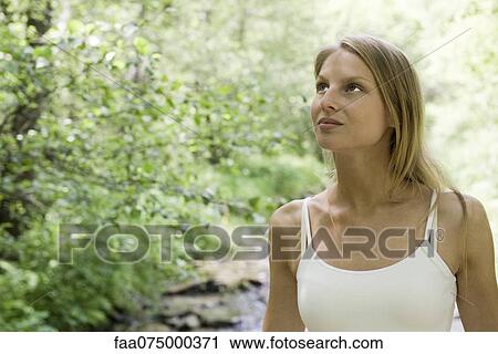 Young woman in woods, portrait View Large Photo Image Stock Image - Young woman in woods, portrait. Fotosearch