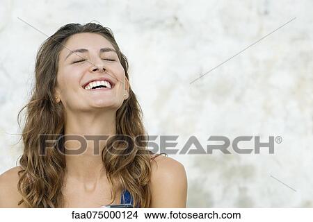 Young woman laughing, eyes closed View Large Photo Image Picture - Young woman laughing, eyes closed. Fotosearch