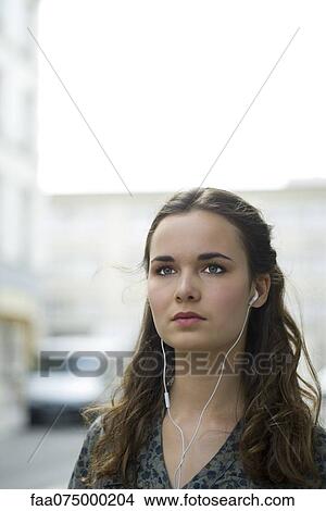 Young woman listening to music with earphones View Large Photo Image Picture - Young woman listening to music with earphones. Fotosearch