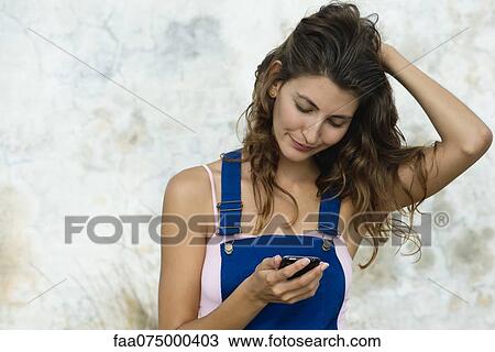 Young woman looking at cell phone View Large Photo Image Stock Image - Young woman looking at cell phone. Fotosearch