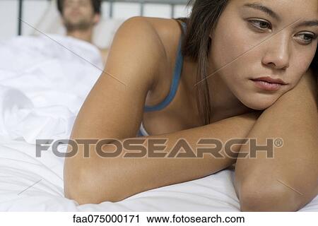 Young woman lying on bed in thought View Large Photo Image Stock Image - Young woman lying on bed in thought. Fotosearch