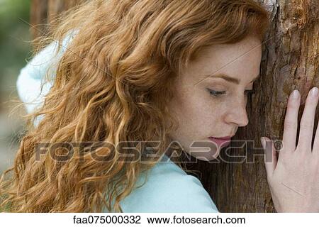 Young woman resting head on tree trunk, portrait View Large Photo Image Stock Image - Young woman resting head on tree trunk, portrait. Fotosearch