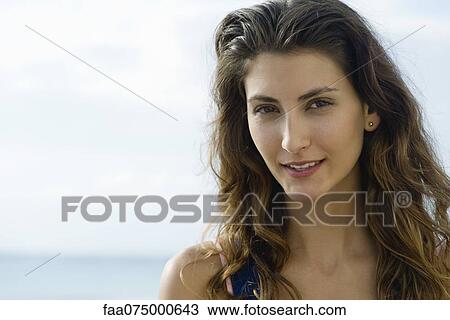 Young woman smiling, portrait View Large Photo Image Stock Image - Young woman smiling, portrait. Fotosearch