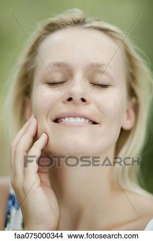 Picture - Young woman smiling with eyes closed. Fotosearch