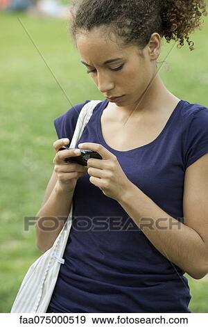 Young woman text messaging with cell phone View Large Photo Image Stock Photo - Young woman text messaging with cell phone. Fotosearch