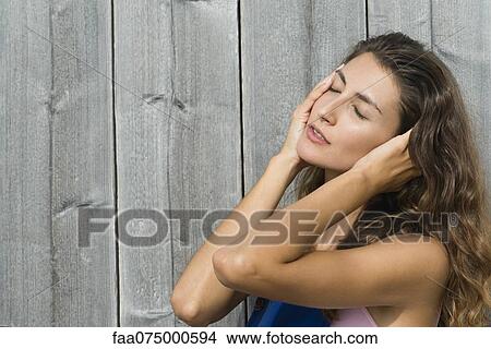 Picture - Young woman touching face, eyes closed, portrait. Fotosearch