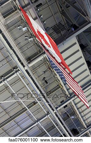 Stock Image - American flag and Canadian flag hanging side by side, low angle view. Fotosearch
