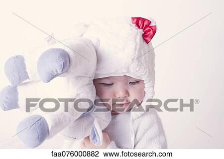 Stock Image - Baby girl hugging stuffed toy. Fotosearch